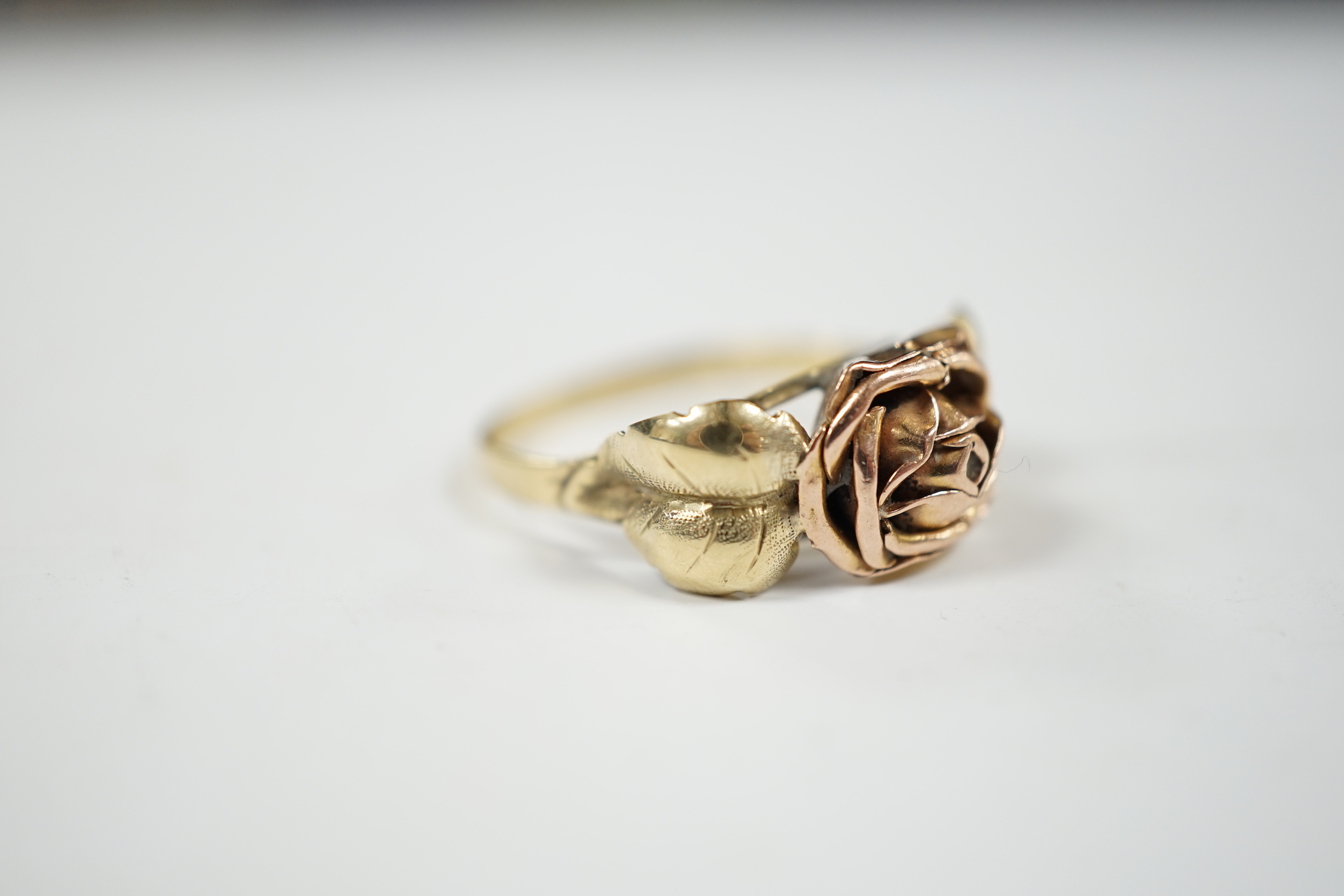 A two colour 585 flower head ring, with leaf shoulders, size P/Q, 3 grams.